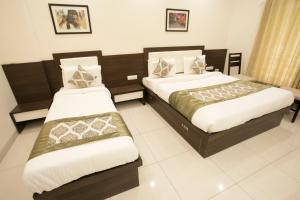 
a hotel room with two beds and two lamps at Hotel Fortune Plaza in Ajmer
