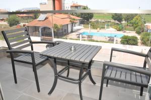 a table and chairs on a balcony with a view of a pool at Riviera Olympus Gods in Paralia Katerinis