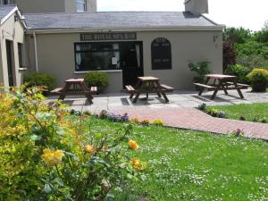two picnic tables in front of a building with flowers at Royal Spa Hotel in Lisdoonvarna