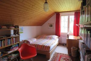 1 dormitorio con cama, escritorio y ventana en B&B Sigrid Braun-Budde, en Bettingen