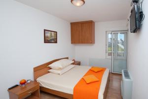 a bedroom with a bed and a tv on a wall at Apartments Lucia in Podstrana