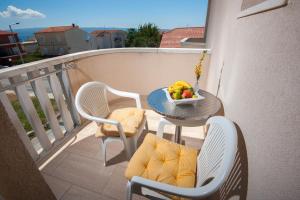 a table with a bowl of fruit on a balcony at Apartments Lucia in Podstrana