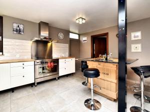 a large kitchen with white cabinets and a stove top oven at Holiday Home in Virton with swimming pool in Virton