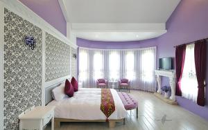 五結鄉的住宿－愛町堡私人會館，紫色卧室配有一张床和一张桌子及椅子