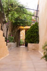 an alley with a building with a door and plants at Kristina´s rooms in Rhodes Town