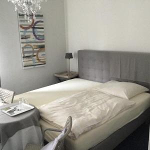 sypialnia z łóżkiem ze stołem i żyrandolem w obiekcie Lindenhof w mieście Hainburg