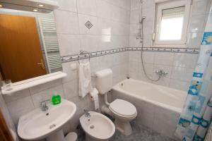a bathroom with a sink and a toilet and a bath tub at Apartments Lucia in Podstrana +28 photos