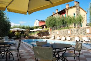 a patio with tables and chairs and a swimming pool at Tenuta Fortelongo in Fara Vicentino