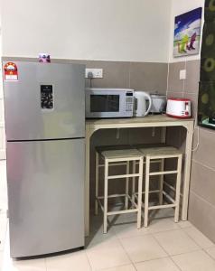 马六甲马六甲乌里希度假屋的厨房配有冰箱和微波炉。