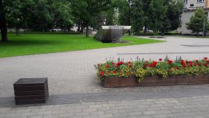 a flower garden with red flowers in a park at Mõisa Ait Apartment in Võru +4 photos