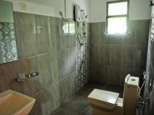 een badkamer met een toilet, een wastafel en een douche bij Resort Beam in Kandy