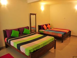 una camera da letto con due letti e uno specchio di Resort Beam a Kandy