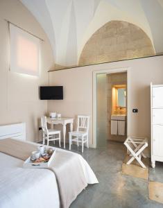 a bedroom with a bed and a table with chairs at Corte Dei Francesi in Maglie