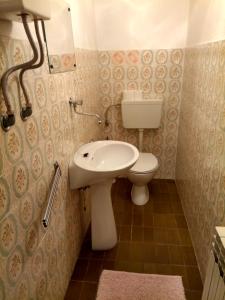 een kleine badkamer met een toilet en een wastafel bij Suran Apartments in Pula