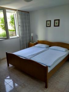 a large bed in a bedroom with a window at Suran Apartments in Pula