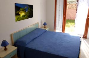 una camera con un letto blu e un casco sul muro di Miriacheddu a San Teodoro