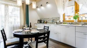 a kitchen with a table and chairs and a sink at Rent like home - Sywarne II in Kościelisko