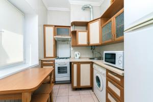 a kitchen with wooden cabinets and a wooden table at Apartment on Khreshchatyk in Kyiv