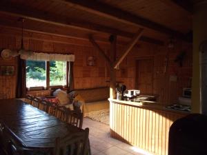 a kitchen and living room of a log cabin at Any Kulcsosház in Sicasău