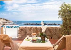 a table with a vase of flowers on it with the ocean at Hotel Rex in Livorno