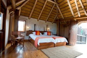 a bedroom with a large bed in a room with wooden floors at Stiltz Guest House in Swakopmund