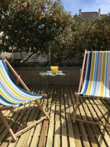 2 Stühle und ein Tisch auf einer Terrasse mit einem Orangenbaum in der Unterkunft Le Wim'Heureux Terrasse in Wimereux