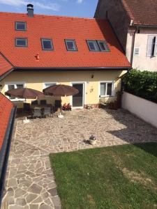 un patio con sombrillas frente a una casa en Ferienwohnung Kickmaier en Bad Radkersburg