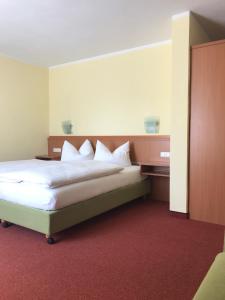 1 dormitorio con 1 cama grande con almohadas blancas en Gasthof Hirsch Betzigau, en Betzigau