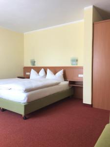 a bedroom with a large bed with white pillows at Gasthof Hirsch Betzigau in Betzigau