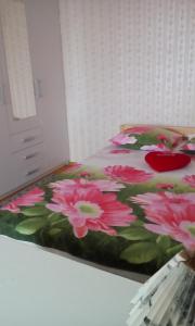 Un dormitorio con una cama con flores rosas. en Frendlen Papiniidu Apartment en Pärnu
