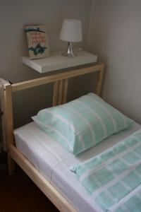 Mcely的住宿－Vejminek U Drahušky Mcely，一张带枕头的床和架子上的灯