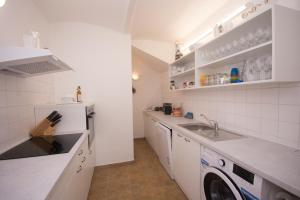 a kitchen with a sink and a washing machine at Penzion Marhulka in Dolní Věstonice