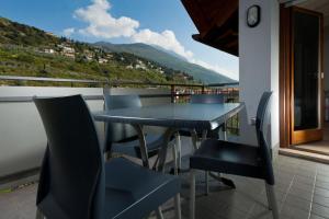 a table and chairs on a balcony with a view at Casa Carla in Nago-Torbole