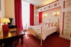 um quarto com uma cama e uma secretária e uma cama sidx sidx em Hotel de la Bretonnerie em Paris