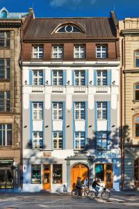 dos personas montando bicicletas en frente de un edificio en Relais Le Chevalier en Riga