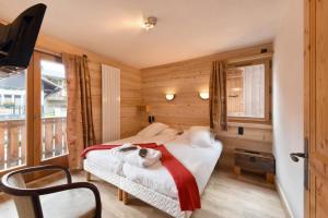a bedroom with a bed with a dog laying on it at Loc'Hotel Alpen Sports in Les Gets +31 photos