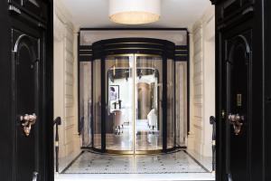 a hallway with a glass elevator in a building at Le Narcisse Blanc in Paris