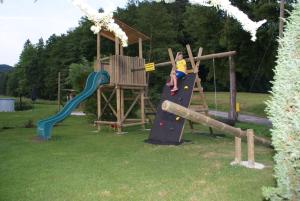 a young boy is climbing up a slide on a playground at Weingut Lieschnegg in Leutschach