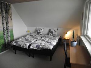 Bed and Breakfast Hasseloe في نيكوبينغ فالستر: غرفة نوم مع سرير في غرفة مع نافذة