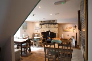 a dining room with a fireplace and tables and chairs at Bertram's in Warkworth