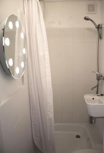 y baño con cortina de ducha y lavamanos. en The Guest Apartment en Viljandi