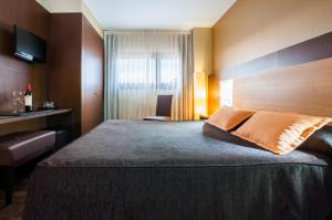 Postel nebo postele na pokoji v ubytování Hotel Ciudad de Alcañiz