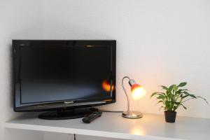 einem Fernseher, der auf einem Tisch mit einer Lampe und einer Anlage sitzt in der Unterkunft La Dent-du-Midi Hôtel & Restaurant in Saint-Maurice