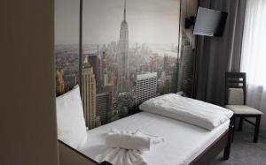 a bedroom with a bed with a view of a city at Hotel City in Koszalin