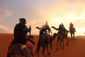 Un groupe de personnes à cheval dans le désert dans l'établissement Panorama chez Hamid, à Moulay Ali Chérif