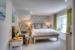 a bedroom with a bed and a chair and a window at Bertram's in Warkworth