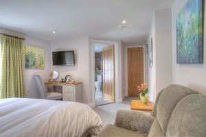 a bedroom with a bed and a chair and a desk at Bertram's in Warkworth
