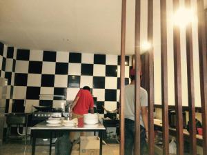 two people standing in a kitchen preparing food at Sari Room Bed & Breakfast in Nusa Dua