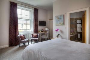 a bedroom with a bed and a desk and a window at Bertram's in Warkworth