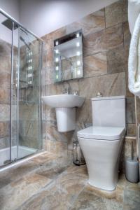 a bathroom with a toilet and a sink and a shower at Bertram's in Warkworth